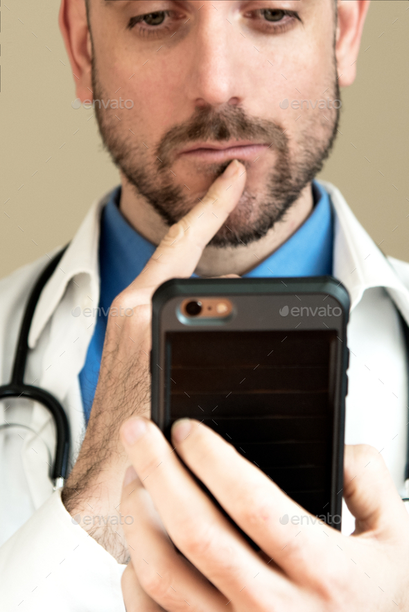 Doctor reading or video chatting on phone device.  - Stock Photo - Images