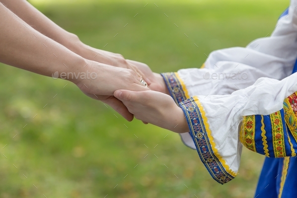 Woman\'s hand holding a baby hand close up. Ukrainian national clothes, Ukraine. No war