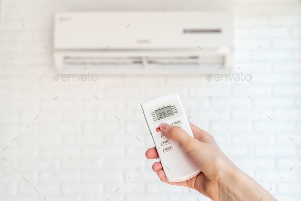 home air conditioner and hand with remote control - Stock Photo - Images