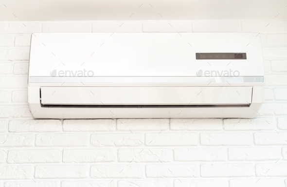 Home air conditioner hangs on a white brick wall. Concepts of health and energy saving. Nobody - Stock Photo - Images