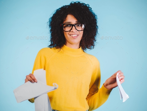 Breaking contract.african american woman with afro hairstyle tearing up paper with pleasure on blue.