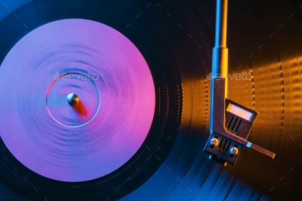 Movie of retro-styled record player spinning vinyl black record.Cinemagraph.Side view.Beautiful neon