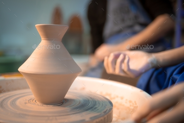 Traditional pottery making, man teacher shows basics of pottery in art studio. Artist operates hands