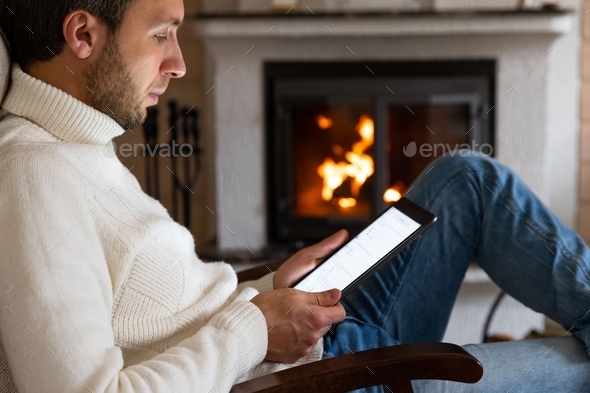 Close up of caucasian man wear high neck white sweater using a digital tablet
