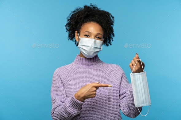 Woman wear anti virus protection face mask to prevent from coronavirus, Covid-19, showing finger