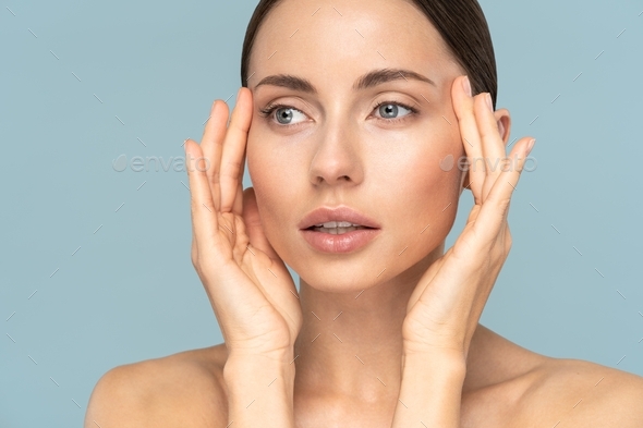 woman with natural makeup, combed hair, touching well-groomed pure skin on face. Beauty, facelift