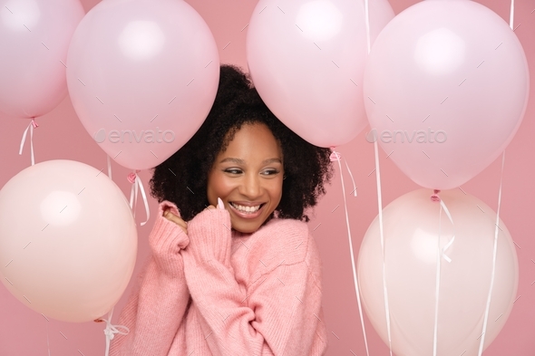 Happy Biracial Woman With Curly Hair Holding A Lot Of Balloons 