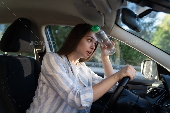 Exhausted girl driver suffering from headache, heat, hot weather ...