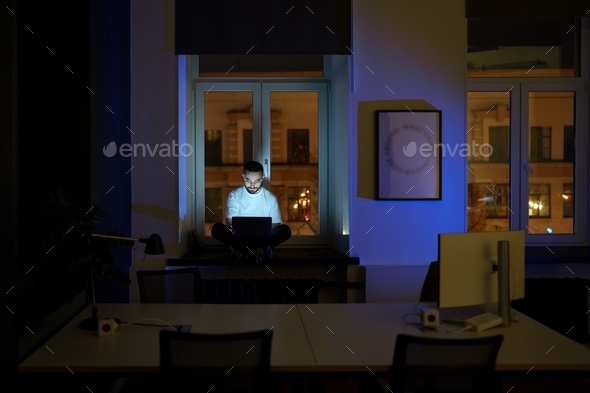Freelancer programmer work on laptop late at night. Web developer coding overtime before deadline