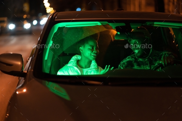 Happy couple in love talk inside car. Man and woman romantic lovers communicate at night after date