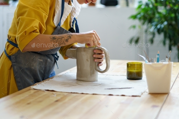 Handmade pottery manufacture process: woman artist hand create jug of ...