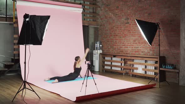 girl fitness blogger shows how to do exercises correctly on a pink background alt