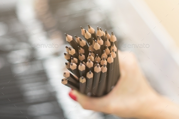 A woman holds a lot of pencils in her hands. Selective focus. Slate pencils for writing and drawing.