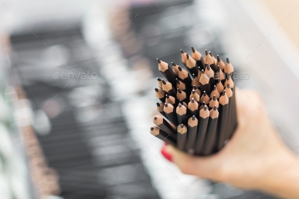 A woman holds a lot of pencils in her hands. Selective focus. Slate pencils for writing and drawing.