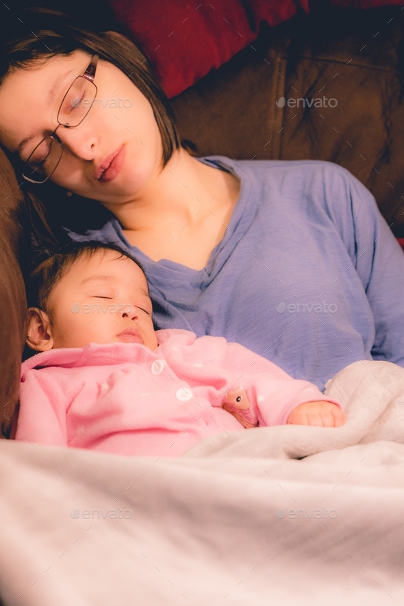 Mother and diverse daughter on couch sleeping Stock Photo by rohaneh