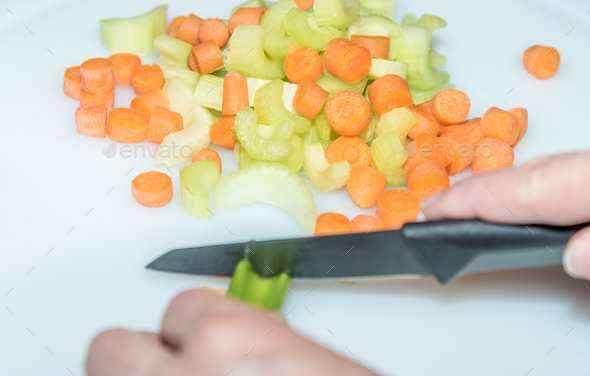 healthy eating: woman cutting vegetables with knife - Stock Photo - Images