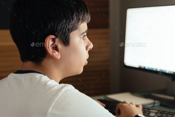 Teenager concentrated studying at home attending online classes