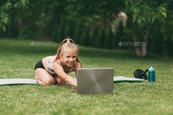A teenage girl practices an online outdoor lesson near her home during quarantine self-isolation