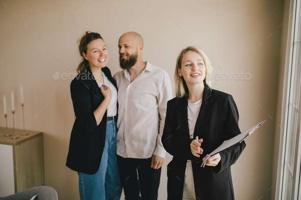Real estate agent demonstrates a new apartment to a happy couple. Buying a property.
