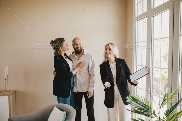 Real estate agent demonstrates a new apartment to a happy couple. Buying a property.