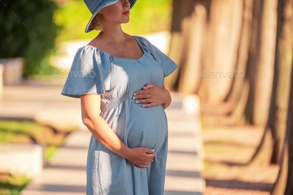 Portrait Of Middle Aged Pregnant Woman In Denim Blue Dress Hat Travel