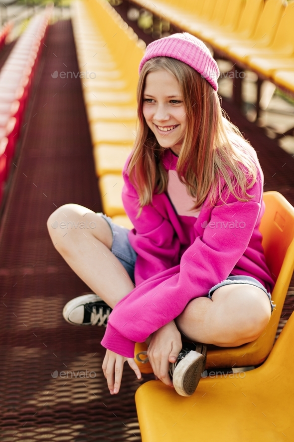 Portrait of a charming girl sitting on the school bleachers during a break