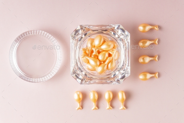 face care oil capsules on pink background. single use nourishing oil for dry and damaged skin