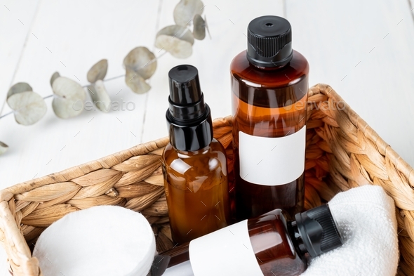 Facial and body care cosmetics dark glass bottles composition in eco basket with dry eucalyptus