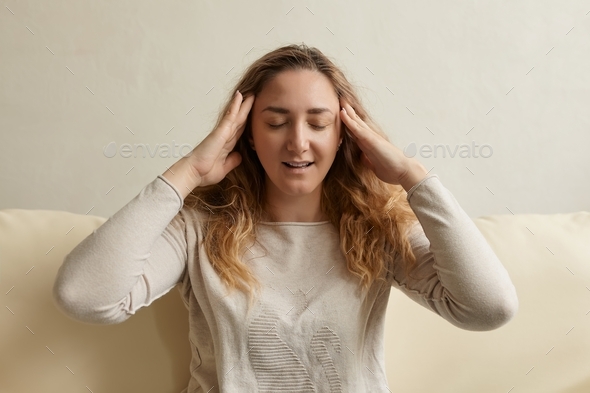 Stressed woman calming down relieving headache emotional stress relief, nervous young woman