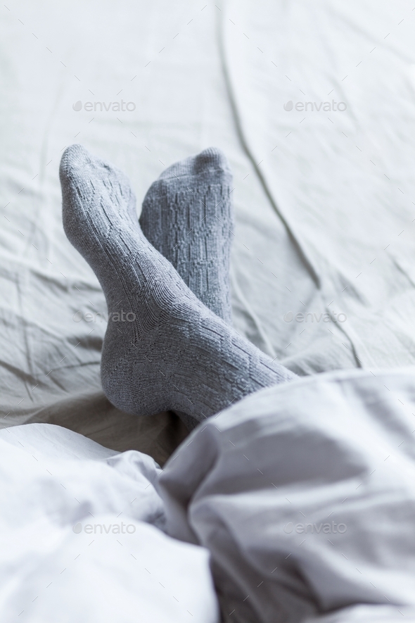 close up of young woman legs in knee socks in bed at home