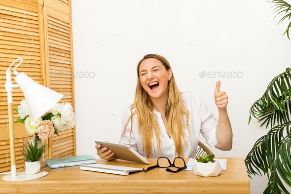 Cheerful young office worker showing thumbs up
