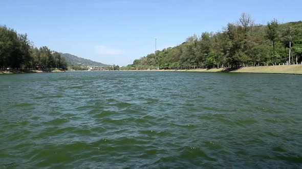 locked low angle shot of panoramic view of Nai Harn Lake on a breezy blue sky summer day, no people, alt