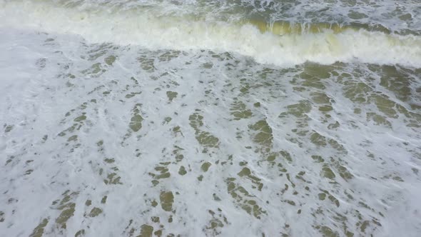 waves and white foam on the sand alt