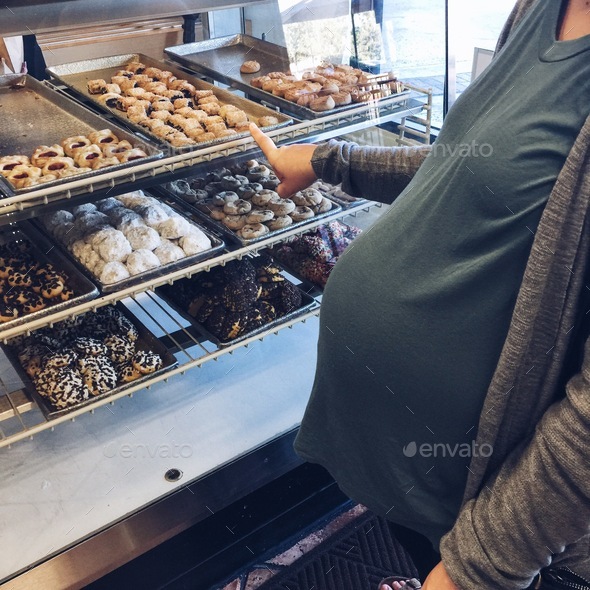 Young pregnant woman craving cookies and sweets in her last trimester