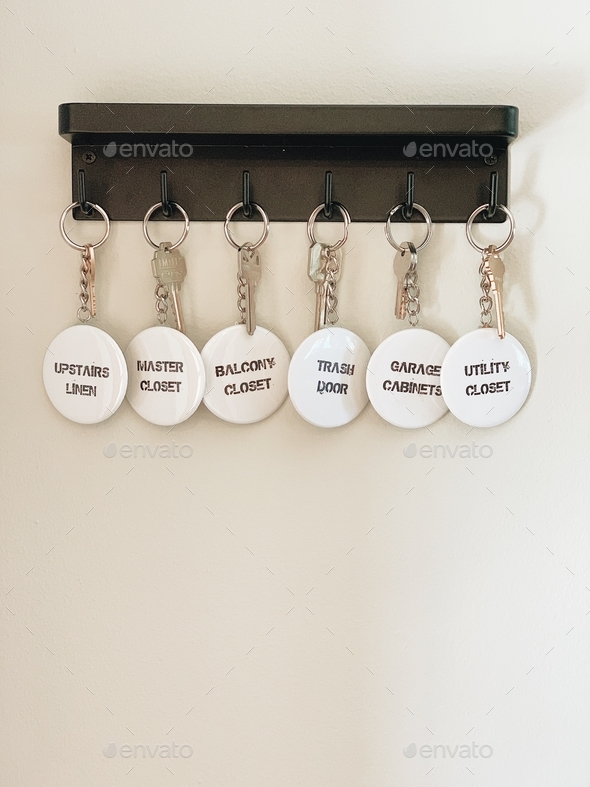 Keychains with labels hang on a light colored wall