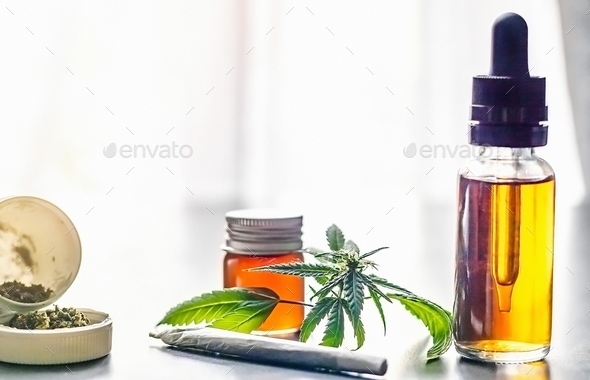 Table with cannabis oils weed joint and leaf - Stock Photo - Images