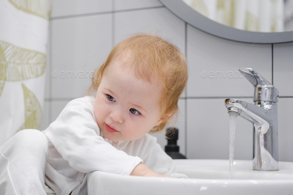 Close Up Of Baby Washing Hands In Sink. Learning And Teaching Children 