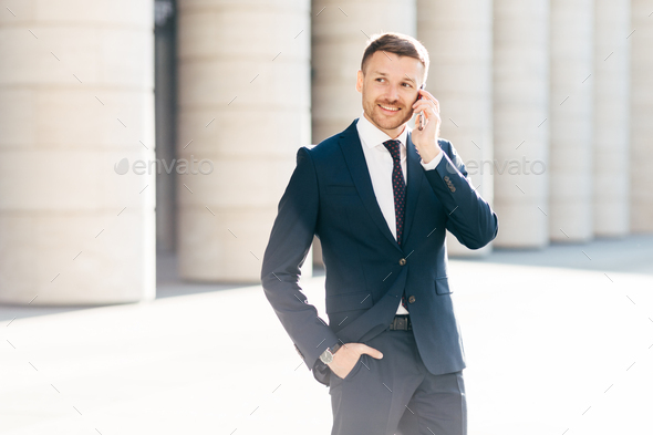 Portrait of successful male manager satisfied with mobile tariffs, makes phone call - Stock Photo - Images