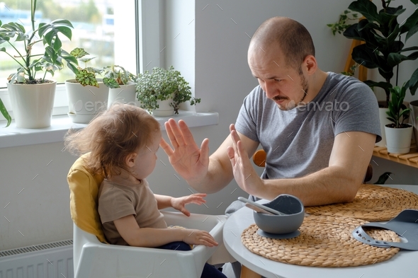 A dad teaching his child hands clapping game. A father playing with baby toddler patty cake game.