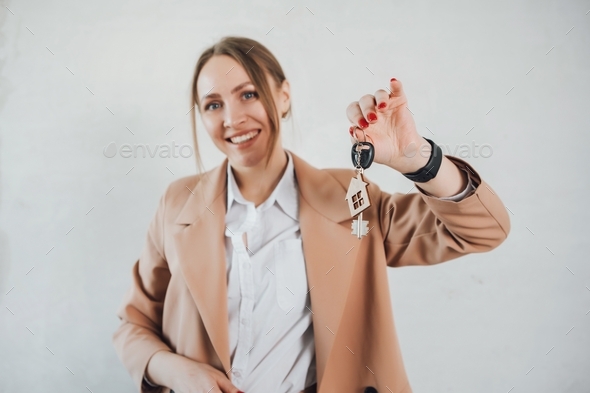 Woman hold keys with house keychain. Real estate agent sold new flat.