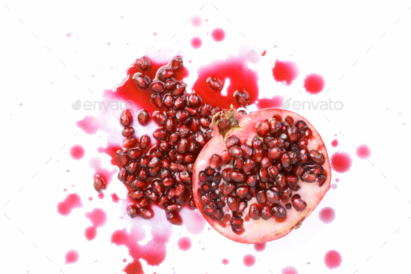 Sliced pomegranate with seeds and juice on white background  - Stock Photo - Images