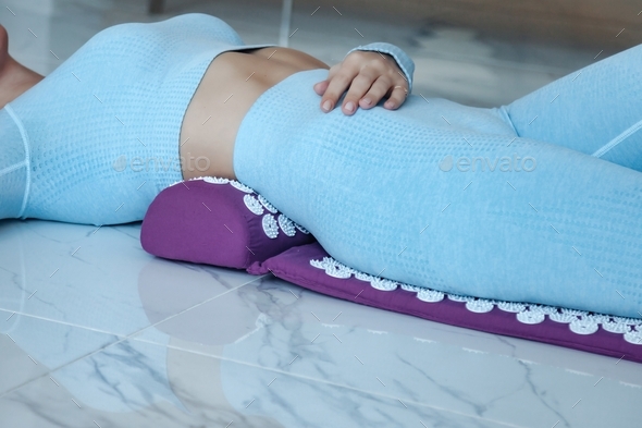 Acupressure mat massage therapy. Close-up young woman lying on orthopedic acupressure mat