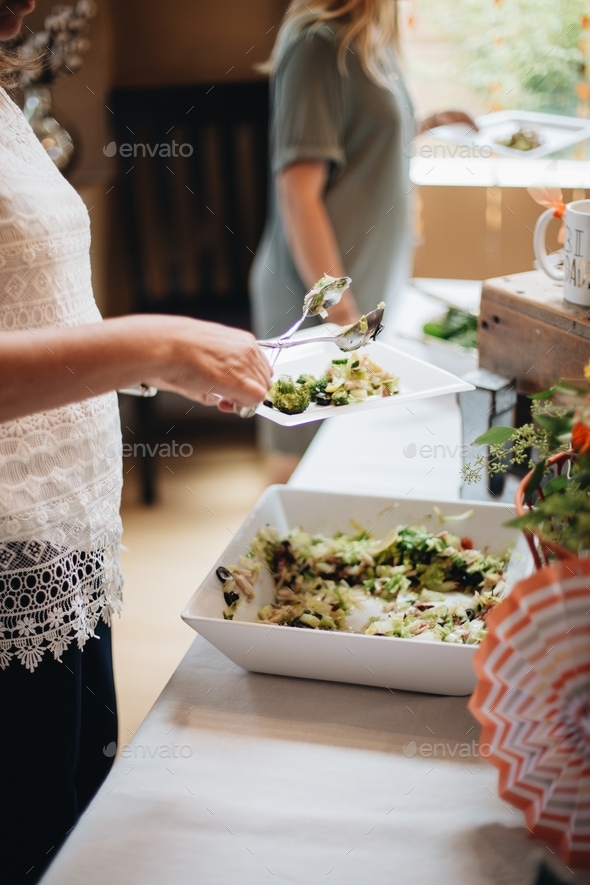 Serving some salad at a baby shower  - Stock Photo - Images