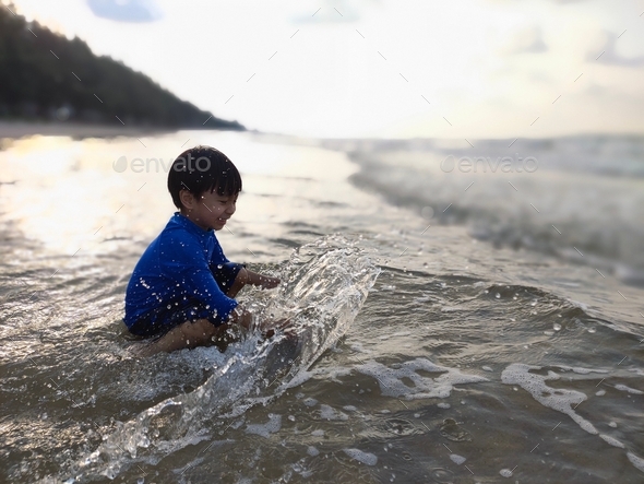 kid playing sea, sea, sunset, beach, sand, happy, lifestyle - Stock Photo - Images