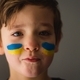 Portrait of a Ukrainian boy with a face painted with the colors of the Ukrainian flag. - PhotoDune Item for Sale