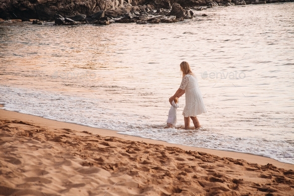 Mother and daughter walking in the waves #debb_a/motherhood, #debb_a/childhood - Stock Photo - Images