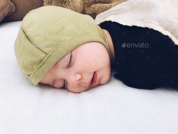 Sleeping baby with a tiny little grin - Stock Photo - Images