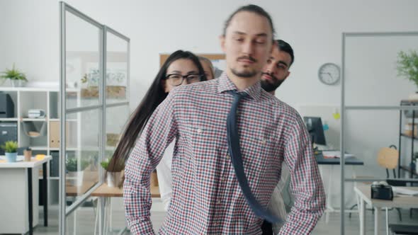 Portrait of Businesspeople Team Dancing in Workplace and Looking at Camera Smiling alt