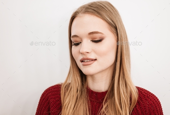 beautiful young blonde woman with a beautiful evening makeup stands in a beauty salon