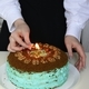 A young Caucasian girl lights a candle on her birthday cake. She&#39;s celebrating her birthday. - PhotoDune Item for Sale